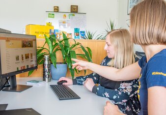 Das Bild zeigt zwei Mitarbeiterinnen, die vor einem Computerbildschirm sitzen und auf der Homepage arbeiten.  | © SONNENTOR