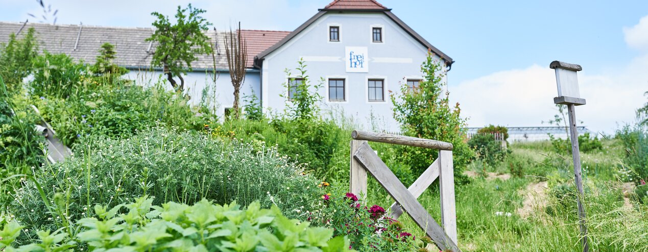 Außenansicht des Bio-Bauernhof Frei-Hof mit blühenden Permakulturgarten | © SONNENTOR Schrägstrich @nudlholz.at
