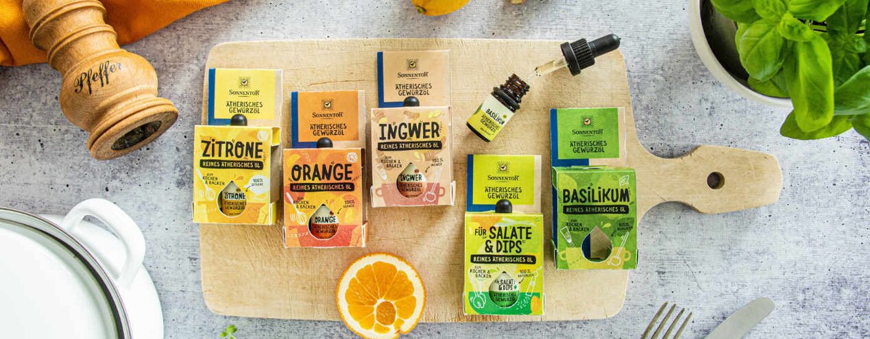 In the photo you can see several SONNENTOR spice oils. Next to them are fresh herbs, ginger, lemon and a pepper mill. | © SONNENTOR
