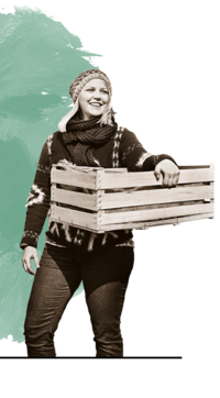 Schwarz-weiß Foto von Bäuerin Prohaska mit einer Kiste in der Hand. Der Hintergrund ist türkis. | © SONNENTOR
