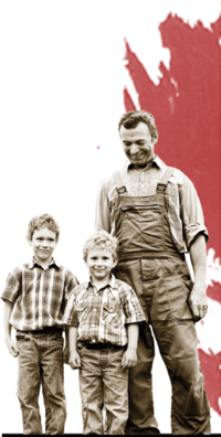 Black and white photo of farmer Poell with two childrend. In the background there is red color. | © SONNENTOR