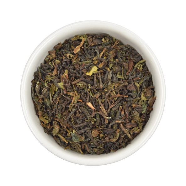 Photo of a small, white bowl filled with SONNENTOR Darjeeling black tea loose