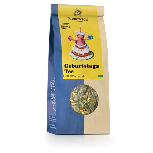 Photo of a pack Happy Birthday Tea loose Organic Herbal Tea Blend. There is a picture of which a pig jumps out of a cake holding a cup of tea in one hand and a gift in the other.