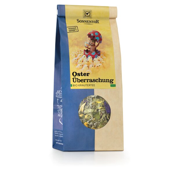 Photo of a pack Easter Surprise Tea loose Organic Herbal Tea Blend. On the package is a picture of many chickens and in the middle is a rabbit that looks out of an easter egg with a hot cup of tea and an egg shell in his hand.