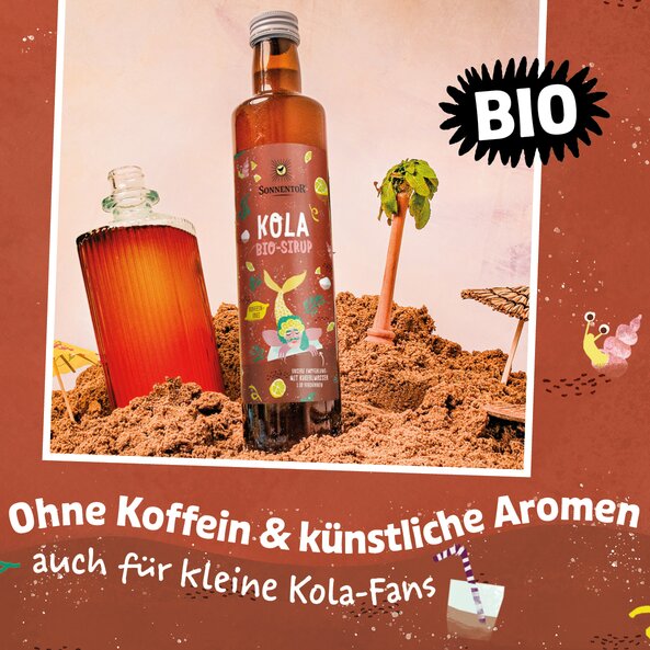 Kola Sirup Flasche in Strandszene mit Getränk, Palme und Text „BIO“ sowie „Ohne Koffein & künstliche Aromen auch für kleine Kola-Fans“ | © SONNENTOR
