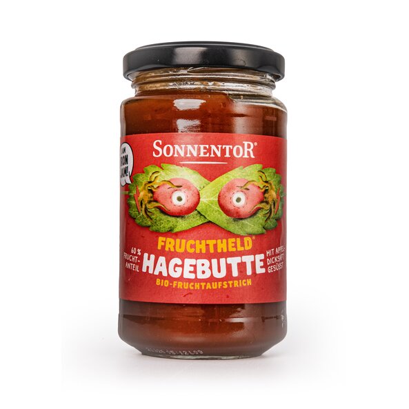Jar of rosehip organic fruit spread. On the label you can see 2 rose hips with eyes. Behind the rosehips are leaves that look like a superhero mask overall. Note: Sweetened with concentrated apple juice. 60% fruit content.