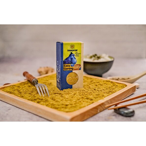Easy Goreng spice loose and in a pack with a window and illustration of a blue monkey eating noodles from a key, on a light green background with the words: ‘For fried rice and noodles’.
