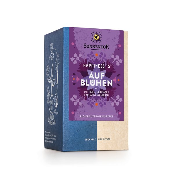 Photo of a pack Blossoming Tea Organic Herbal Spice Tea Blend. On the package is an illustration with floral background in violet turquoise with the inscription Happiness is blossoming.