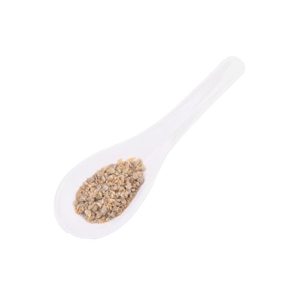 The picture shows a white spoon with green coffee on it.