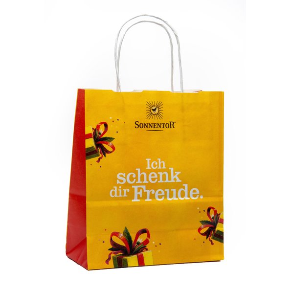 In the photo you can see a yellow paper tote bag with the inscription Ich schenke dir Freude.