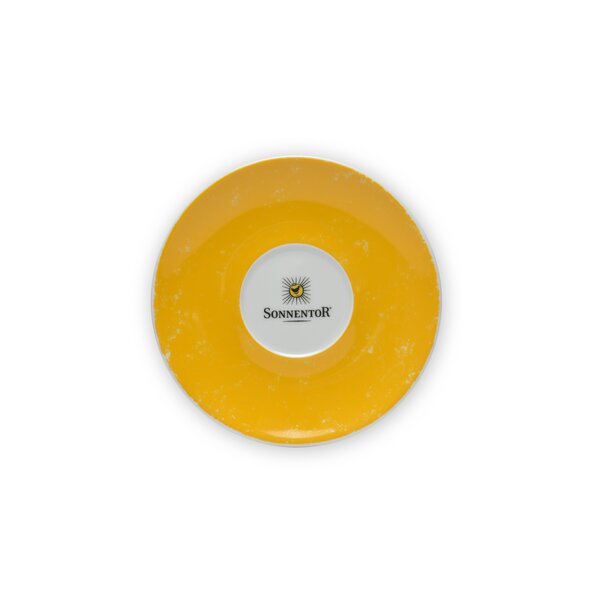 In the photo you can see the sun tea saucer. It is yellow and in the middle you can see the Sonnentor logo.