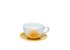 Photo of the sun tea cup and saucer. The white cup with a yellow sun on it stands on a yellow saucer.