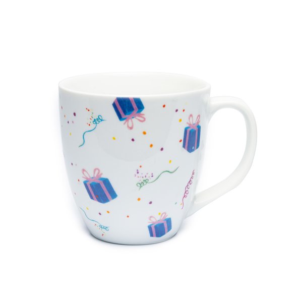 The photo shows a tea cup with gifts, paper snakes and confetti on it.