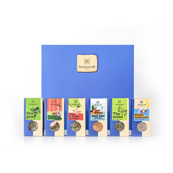 Auf dem Foto ist ein blauer Geschenkkarton zu sehen. Davor sind sechs italienische Gewürze platziert.