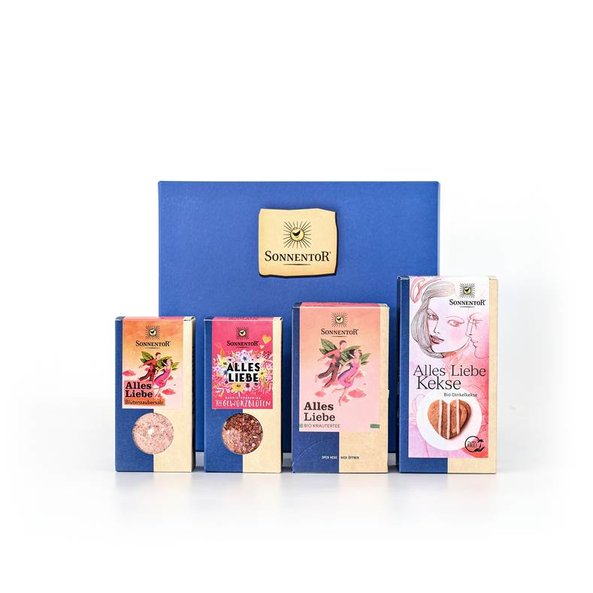 Foto eines blauen Geschenkkarton. Davor sind verschiedene alles Liebe Sonnentor Produkte zu sehen.