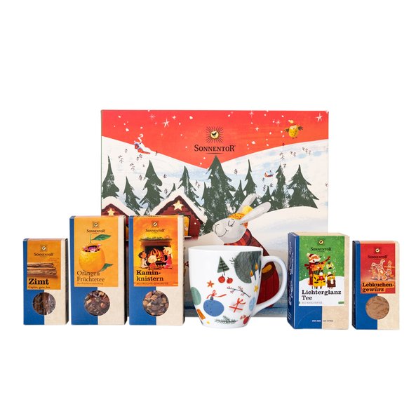 Auf dem Foto sieht man einen Weihnachtlichen Geschenkkarton mit vielerlei weihnachtlicher SONNENTOR Produkte davor.