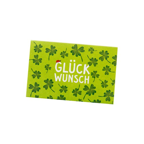 In the photo there is a green gift card with dark green shamrocks. In the middle of the card it says congratulations.
