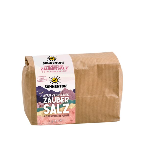 Photo of a gianz-size pack ayurveda magic salt. On it you can see colorful mountains. Through a small window you can see the pink salt.