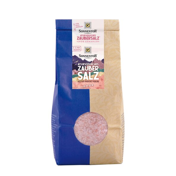 Photo of a gianz-size pack ayurveda magic salt. On it you can see colorful mountains. Through a small window you can see the pink salt.