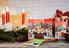 Photo of opened tea Advent calendar. Next to it you can see advent wreath with candles on it. | © SONNENTOR