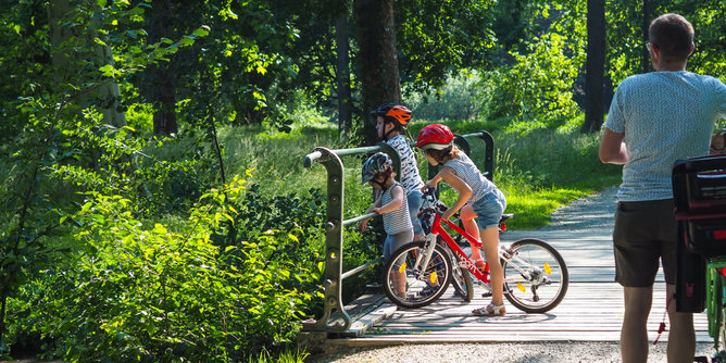 Auf dem Foto ist eine Familie beim Radfahren zu sehen. | © SONNENTOR