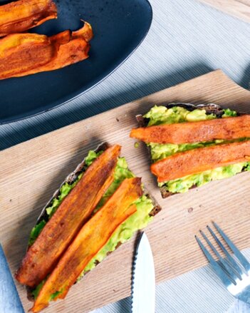 Auf dem Foto sind zwei Scheiben Brot mit Aufstrich zu sehen. Darauf liegt Karotten Bacon. | © SONNENTOR